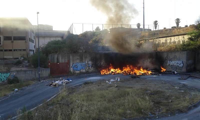 Discarica abusiva data alle fiamme davanti all’ex scuola Brancati: “Città in pericolo ma nessuno interviene”