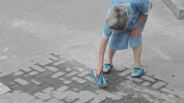 Marciapiede rotto, nonnina stanca della polvere lo ripara da sola: rischia sanzione