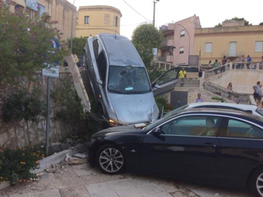 Paura nella piazza del municipio, auto sfonda muretto e precipita su vetture parcheggiate: ferite mamma e figlia