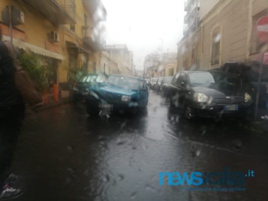 Pioggia battente a Catania, auto rimane “incastrata” in tombino: disagi anche nell’hinterland – VIDEO