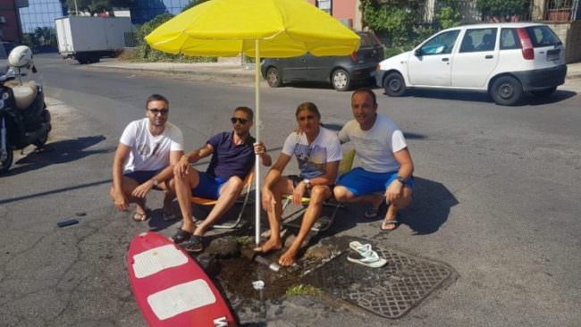 Catania, singolare protesta di alcuni consiglieri. Infradito e costume per una voragine mai risanata: “È una vergogna”