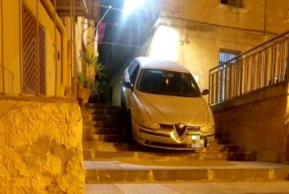 Svolta a destra e finisce “incastrato” su una scalinata: Alfa Romeo in bilico, paura per un uomo