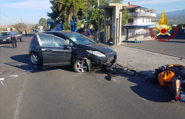 Incidente nel Catanese, le FOTO dell’impatto di questa mattina: motociclista bloccato sotto l’auto