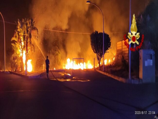 Rifiuti e sterpaglie a fuoco vicino a distributore di benzina: pompieri in azione – FOTO