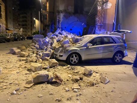 Crolla muro di una palazzina fatiscente a Palermo: grossi detriti in strada, automobile distrutta