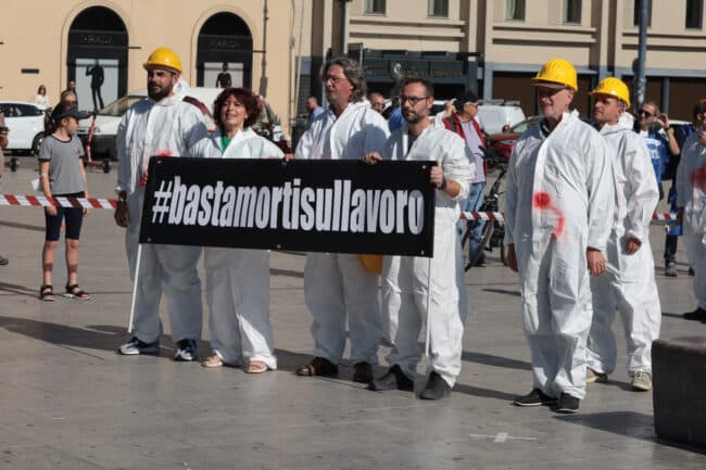 Sdraiati con la tuta sporca di sangue, il flash mob dei sindacati contro le morti sul lavoro – VIDEO