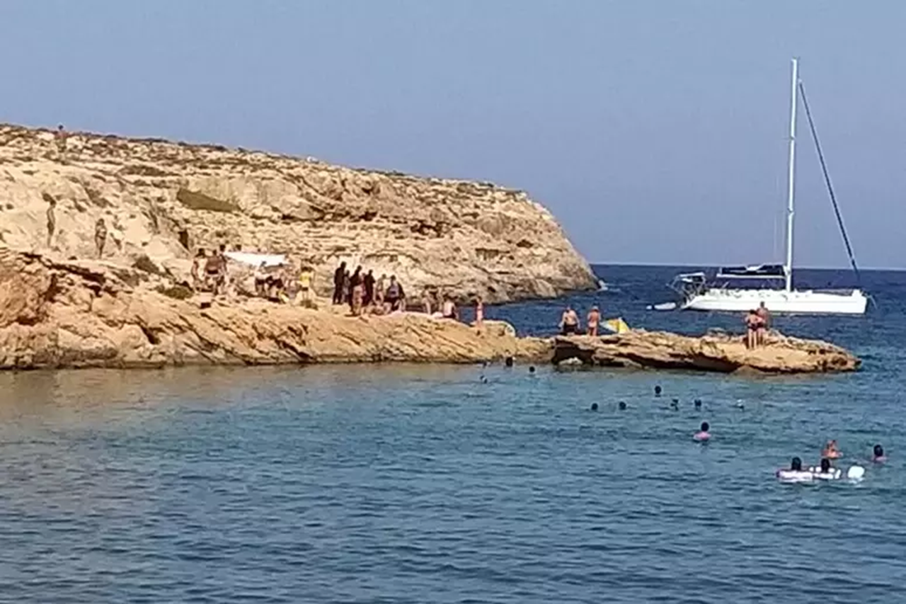 Migranti sbarcano a Lampedusa e i turisti si prendono cura di loro