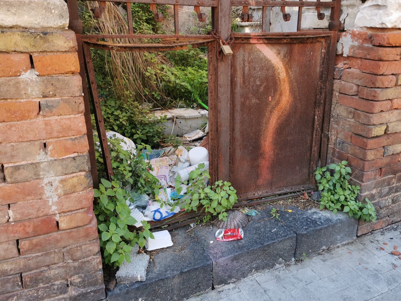 Catania, cancelli arrugginiti e ingressi sbarrati dai rifiuti: l’edificio abbandonato in via Ala
